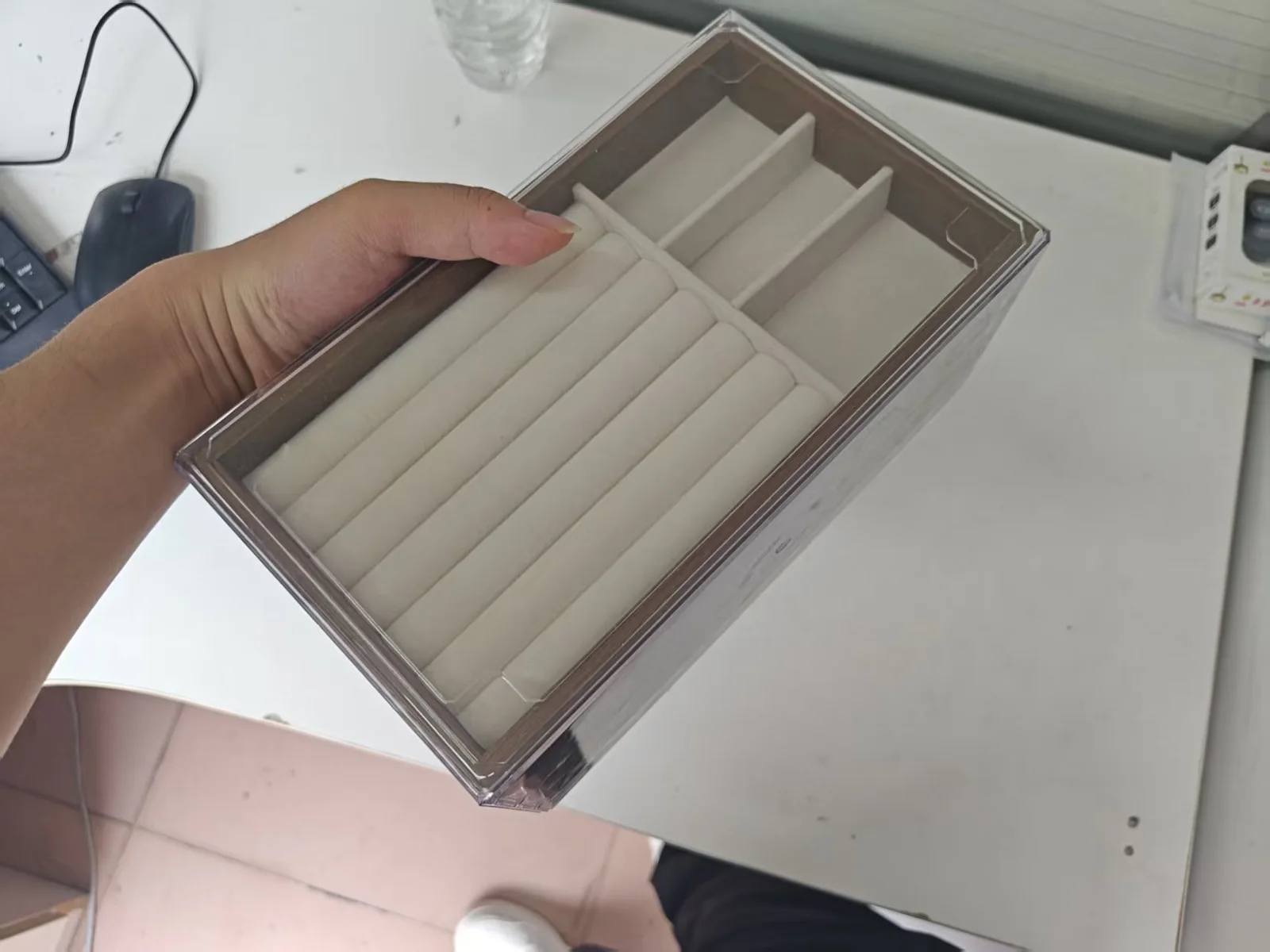 Long jewelry organizer box shown with hand for scale